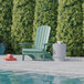 A seafoam green Flash Furniture faux wood Adirondack chair next to a pool.