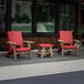 Two red Mayne Mesa chairs on an outdoor patio.