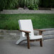 A white Mayne Mesa patio chair in a yard.
