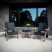 A group of Mayne Mesa black chairs and a table on a patio.