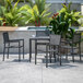 A Flash Furniture black polyresin table with four chairs on a patio.