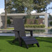 A Flash Furniture black Adirondack chair with ottoman on the grass.