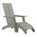 A gray wooden Adirondack chair with a foot rest.