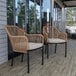 Two Flash Furniture Kallie natural wicker arm chairs with ivory cushions on a wood deck.