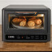 A Blackstone combination pizza oven and air fryer with food cooking inside.