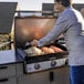 A man cooking food on a Blackstone outdoor griddle.