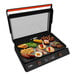 A Blackstone electric tabletop griddle with food cooking on it.