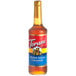 A close-up of a Torani Brown Sugar Cinnamon Flavoring Syrup bottle full of brown liquid.