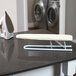 A white Household Essentials Tabletop ironing board on a black counter.