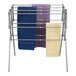 A silver Household Essentials metal drying rack with towels on it.