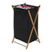 A black laundry hamper with a black bag on a bamboo X-frame.