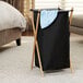 A black Household Essentials laundry hamper with a blue towel on it.