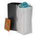 A white Household Essentials laundry bag on a metal and wood laundry hamper.