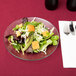 An Anchor Hocking glass plate with a salad on it.