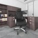 A Boss black leather high-back office chair with white stitching.