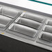 A silver Vollrath stainless steel rectangular food pan on a metal surface.