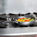 A Vollrath Wear-Ever aluminum non-stick fry pan with vegetables cooking on a stove.