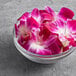 A bowl of pink and white orchids on a table.