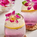 A cocktail with a purple orchid on the rim.