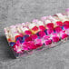 A rectangular case of mixed pink, purple, and white orchids.