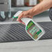 A hand holding a spray bottle of Simple Green Lemon Verbena Scented Multi-Surface Floor Care.