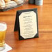 A Choice beige menu on a table with a beer glass and a glass of beer.
