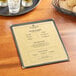 A Choice gold menu on a table with a glass of wine and a plate of food.
