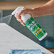 A hand using Simple Green granite and stone polish to spray a kitchen counter.