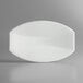A white oval Vollrath melamine platter on a gray surface.