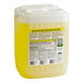 A white plastic container of yellow liquid with a yellow label for Simple Green Lemon Scent Concentrated Industrial Cleaner and Degreaser.