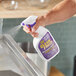 A person spraying Simple Green Mint Scented Disinfectant Cleaner on a metal counter.