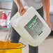 A person pouring Simple Green Crystal Concentrated Industrial Cleaner into a bucket.