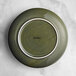 An Acopa Highlands juniper green coupe plate with a white rim.
