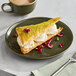 An Acopa Highlands juniper green coupe plate with dessert and a cup of coffee.