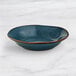 An Acopa Highlands skyfall blue bowl on a marble surface.