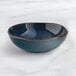 An Acopa Highlands blue china bowl on a marble surface.