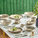 A table set with Acopa Highlands heather gray rectangular china trays, plates, and bowls.