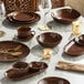 A brown bowl on a table set with brown plates and utensils.