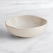 An Acopa Highlands white china sauce cup on a marble surface.