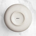 A white bowl with a black circle in the middle.