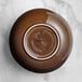 An Acopa Highlands brown china bowl with a white rim on a marble surface.