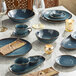 A table set with blue Acopa Highlands sauce cups and plates.