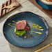 An Acopa Highlands Skyfall Blue coupe china plate with a piece of meat on it.