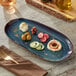 An Acopa Highlands skyfall blue rectangular china tray with food and a fork on a table.