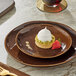 A Acopa Highlands hazel coupe china plate with dessert and a strawberry on it.