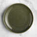 An Acopa Highlands juniper green coupe china plate on a marble surface.