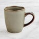 A heather gray Acopa Highlands china mug with a handle on a marble surface.