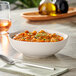 An Acopa Highlands white china bowl filled with food on a table.