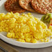 A plate of scrambled eggs and fruit.