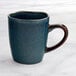 An Acopa Highlands Skyfall blue china mug with a brown handle.